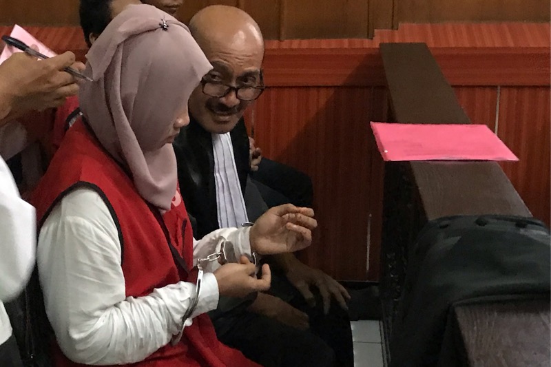Ayuk alias Puspita, terdakwa perdagangan orang (berjilbab) tengah berbincang dengan seseorang usai menjalani sidang di PN Surabaya.