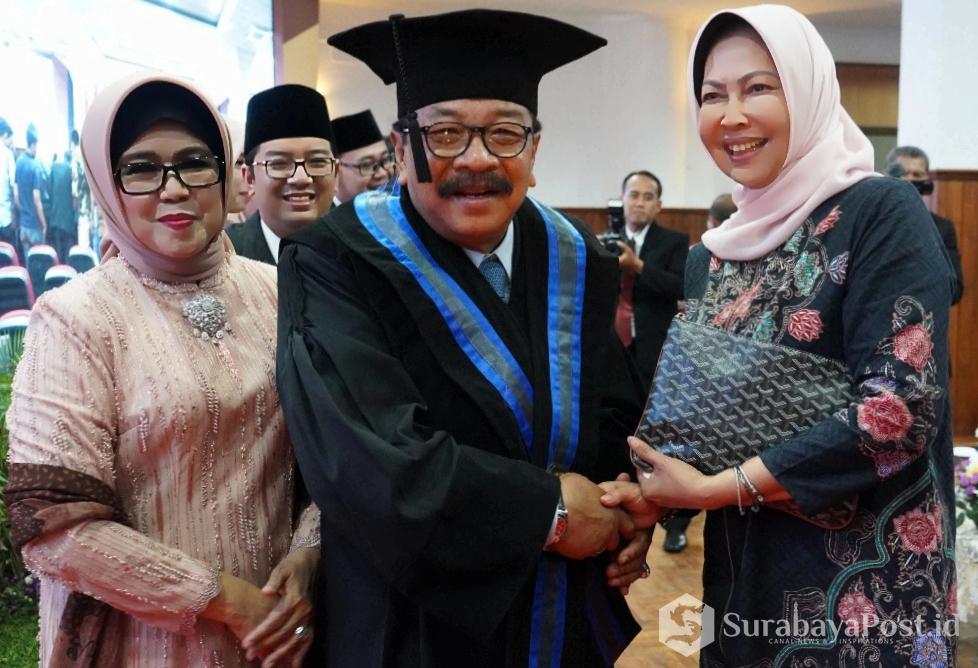 Gubernur Jatim Dr H Soekarwo SH MH MBA saat menerima ucapan selamat dari Wali Kota Batu Hj Dewanti Rumpoko usai menerima gelar Doktor Honoris Causa di UMM
