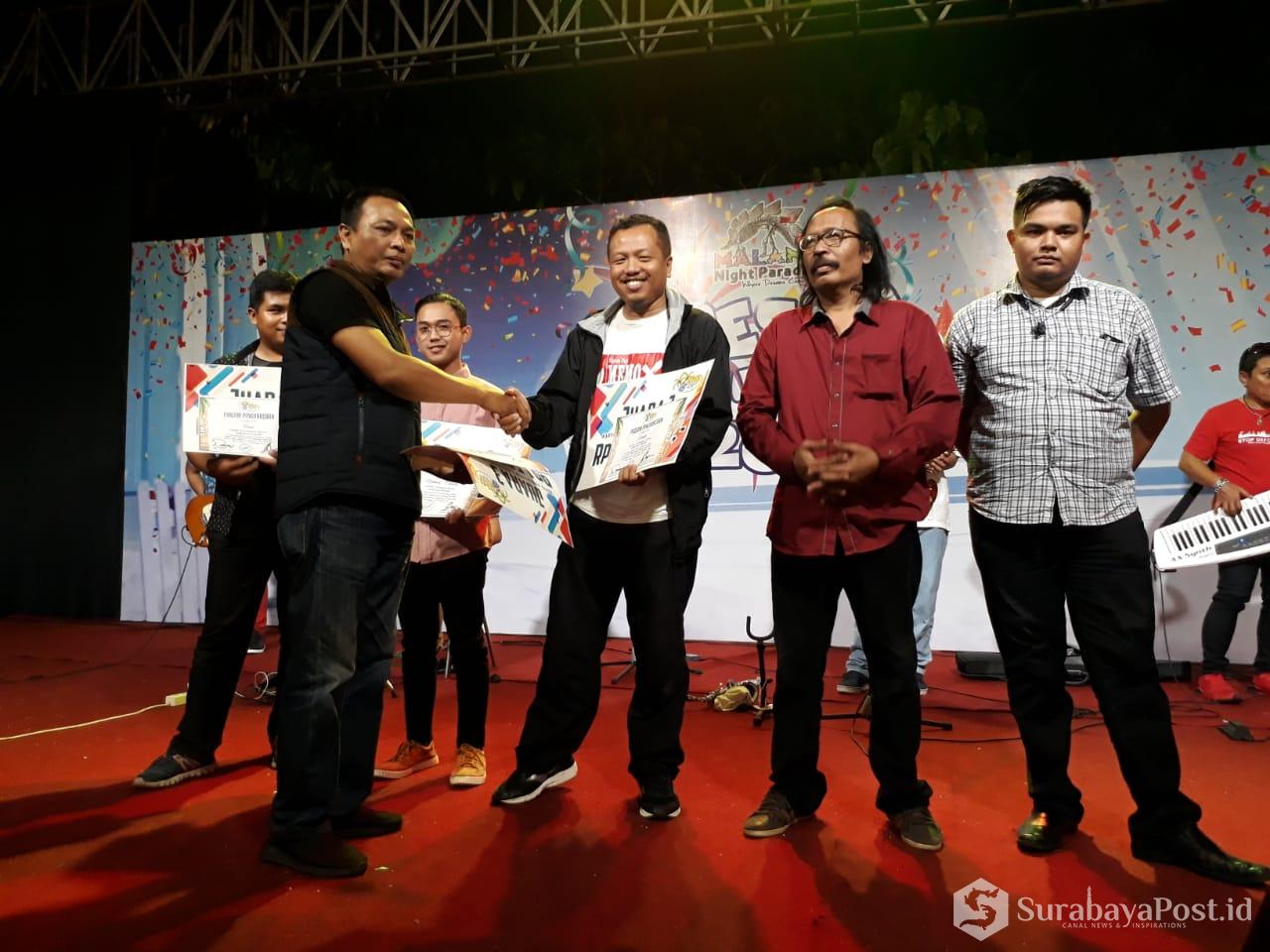 Ketua Panitia Cahyono menyerahkan hadiah kepada para pemenang Lomba Karya Jurnalistik di Hawai Waterpark Malang.