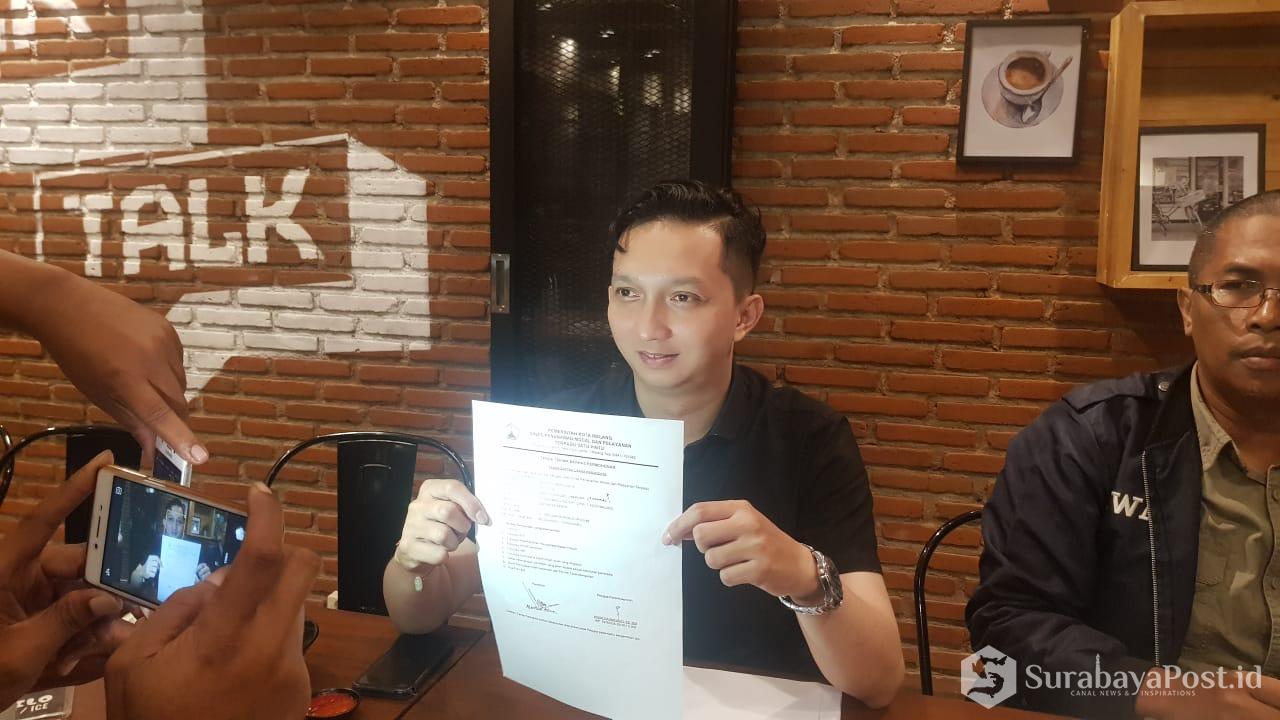 Widi Bagus Prasetyo perwakilan owner cafe Warunk Upnormal menunjukkan surat pengajuan izin usahanya yang masih diproses.