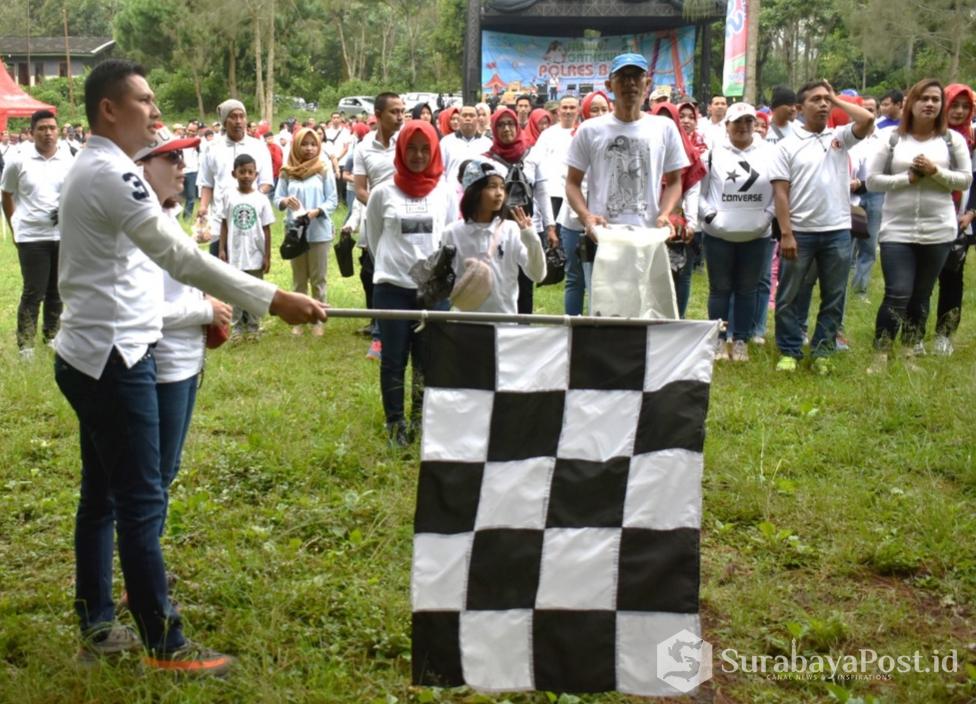 Kapolres Batu AKBP Budi Hermanto melepas peserta jalan sehat sambil bersih-bersih jalan.