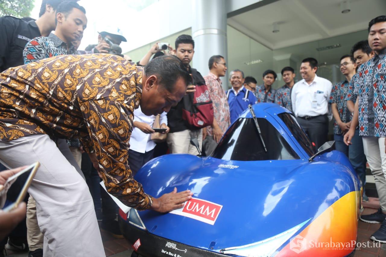 Rektor UMM Dr Fauzan MPd masing stiker pada mobil buatan mahasiswa Fakultas Teknik yang bakal diikutsertakan dalam lomba mobil listrik hemat energi di Sirkuit Sepang Malaysia.