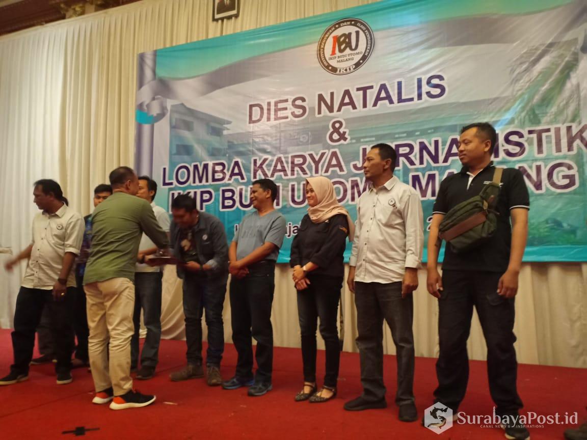 Wartawan SurabayaPost.id, Agus Susanto menerima hadiah dari Rektor IKIP Budi Utomo Malang, Dr H Nurcholis Sunuyeko MSI, sebagai juara pertama dalam lomba jurnalistik kategori media online.