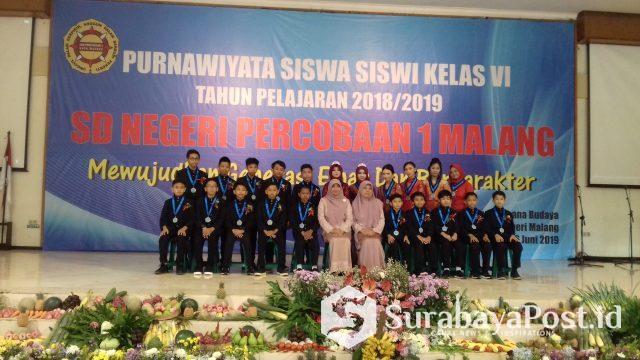 20190616_090741 Siswa Kelas VI A yang dinyatakan lulus pose bersama dengan Wali kelas dan Kepala SDN Percobaan 1 Kota Malang Anny Saida dalam prosesi Purnawirawan Siswa Siswi Kelas VI tahun 2018/2019 di Sasana Budaya UM, Minggu (16/6/2019).