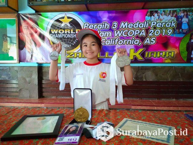 IMG-20190803-WA0088 Izabelle Kiara Kurniawan menunjukkan tiga medali yang diraih di ajang kompetisi WCOPA, California, Amerika Serikat.