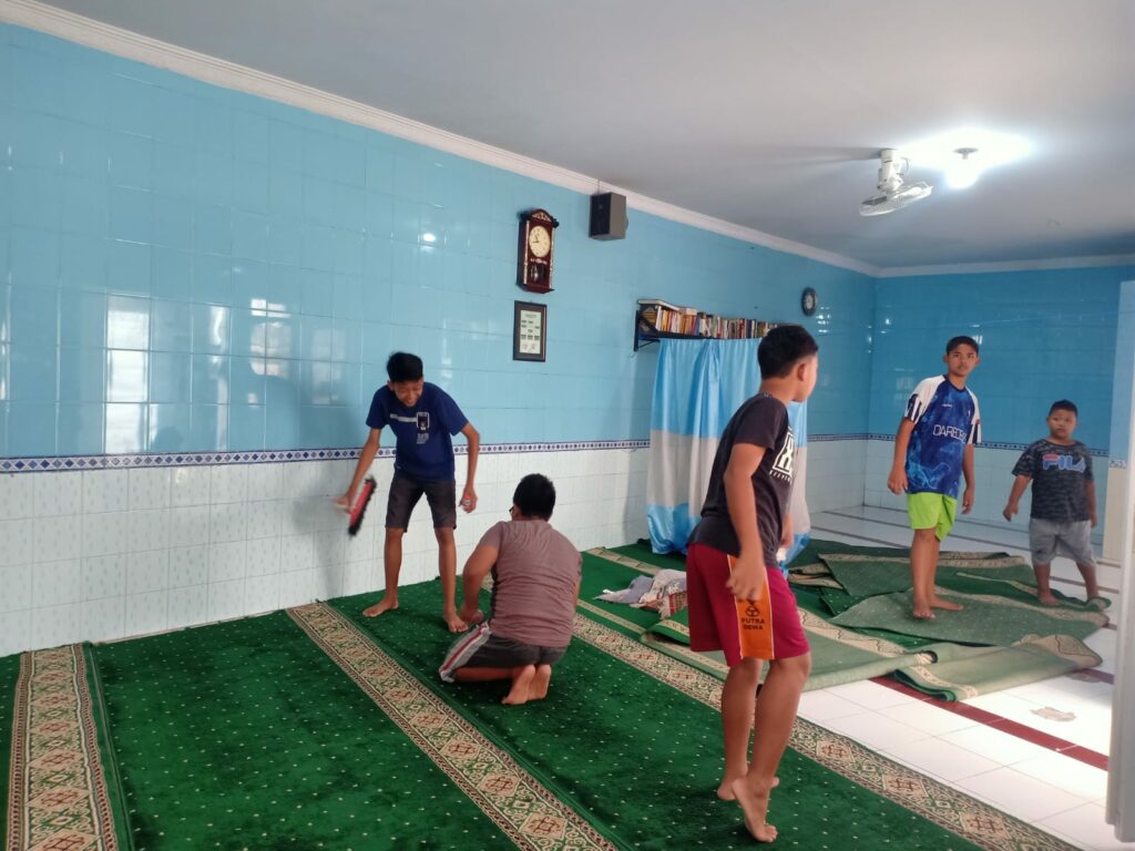 Anak - anak tampak membersihkan bagian dalam masjid Babul Hidayah