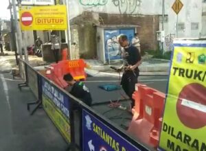 Petugas saat melakukan penutupan akses jembatan Tunggulwulung - Tlogomas, dengan cara memasang besi yang dilas (ist)