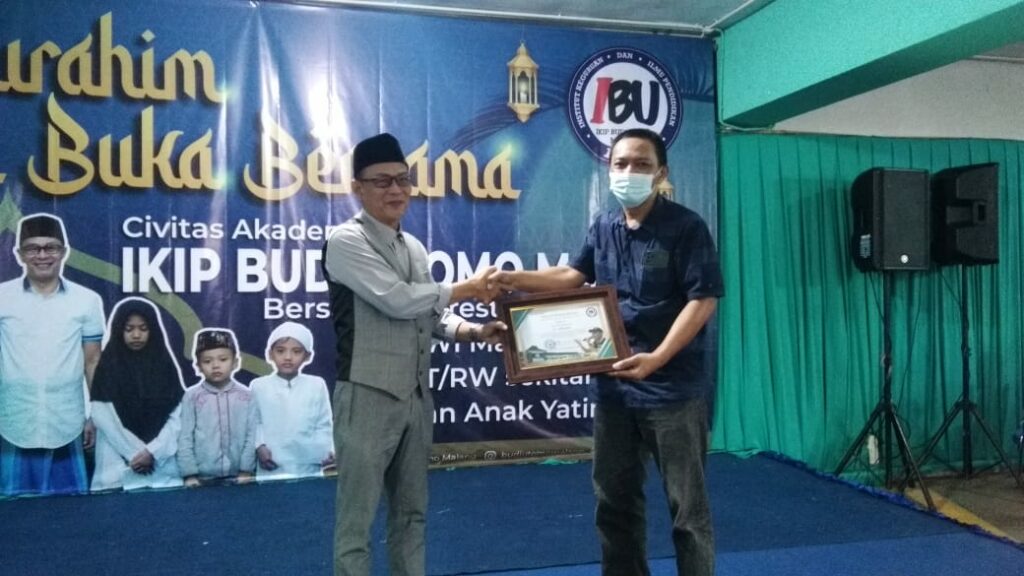 Rektor IKIP Budi Utomo Malang, Nurcholis Sunuyeko menyerahkan piagam penghargaan kepada Ketua PWI Malang Raya, Cahyono