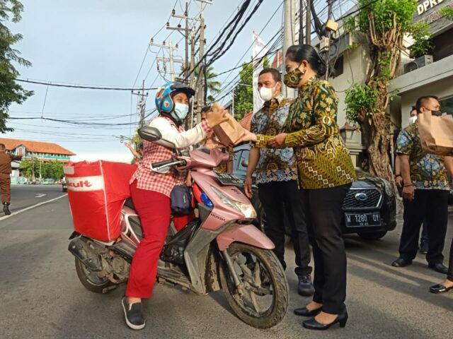 Ketua IAD Tanjung Perak Eka Kasna membagikan paket bingkisan Takjil bagi pengendara di Jalan Kemayoran Baru, Surabaya/ Junaedi (surabayapost.id)