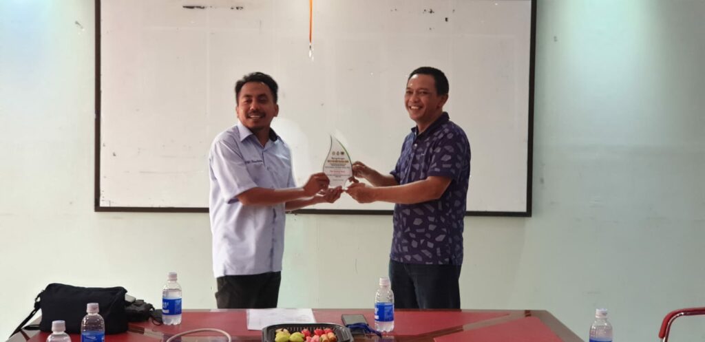 Ketua PWI Malang Raya, Ir Cahyono menerima cinderamata dari koordinator kunjungan, Khairul Anam
