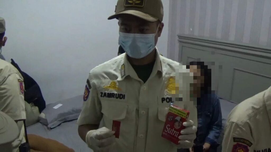Anggota Satpol PP menunjukan salah satu barang bukti Kondom saat menggelar operasi (ist)