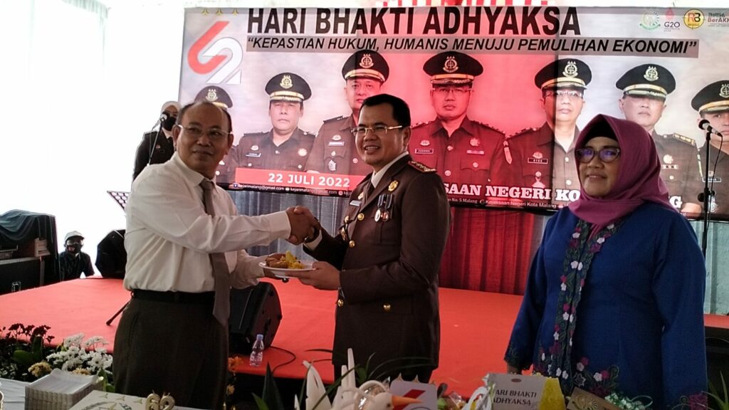 Kajari Kota Malang, Zuhandi, SH, MH didampingi Ketua IAD Ny Indah Zuhandi, memberikan potongan nasi tumpeng kepada pegawai senior