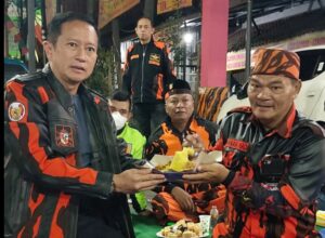 Deddy Irfan Alwany ketika menyerahkan potongan tumpeng kepada sesepuh anggota PP