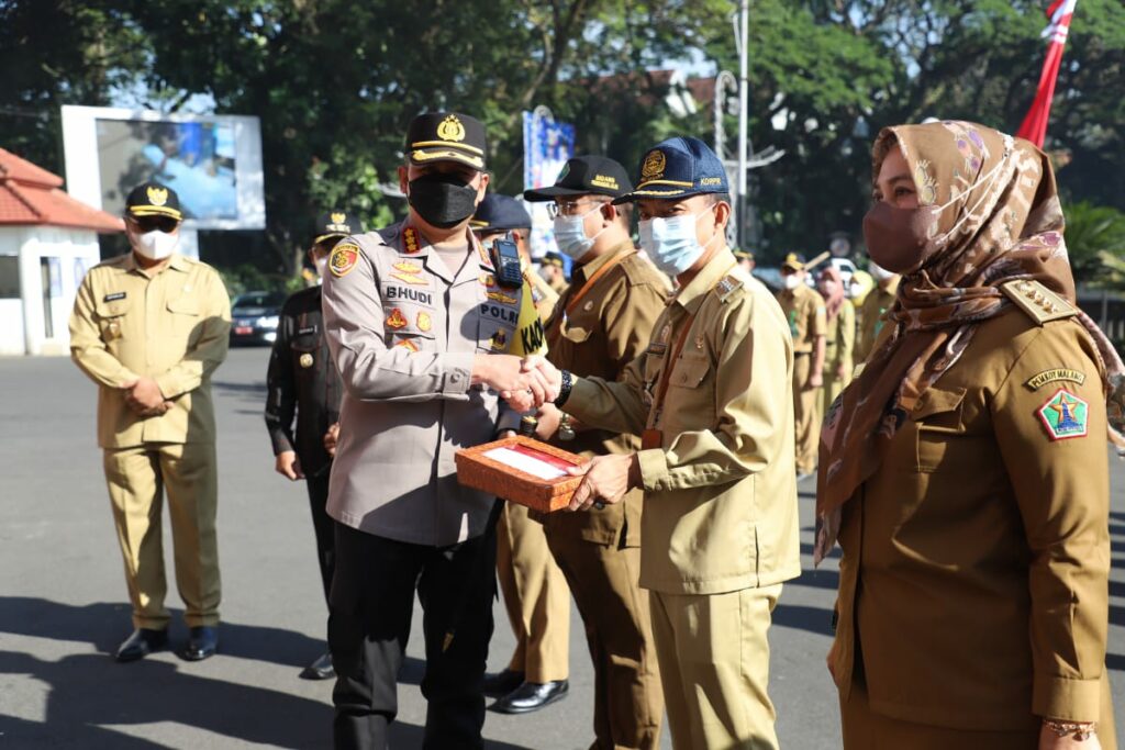 Kombes Pol Budi Hermanto menyerahkan bendera merah putih kepada Camat Sukun, Widi (ist)