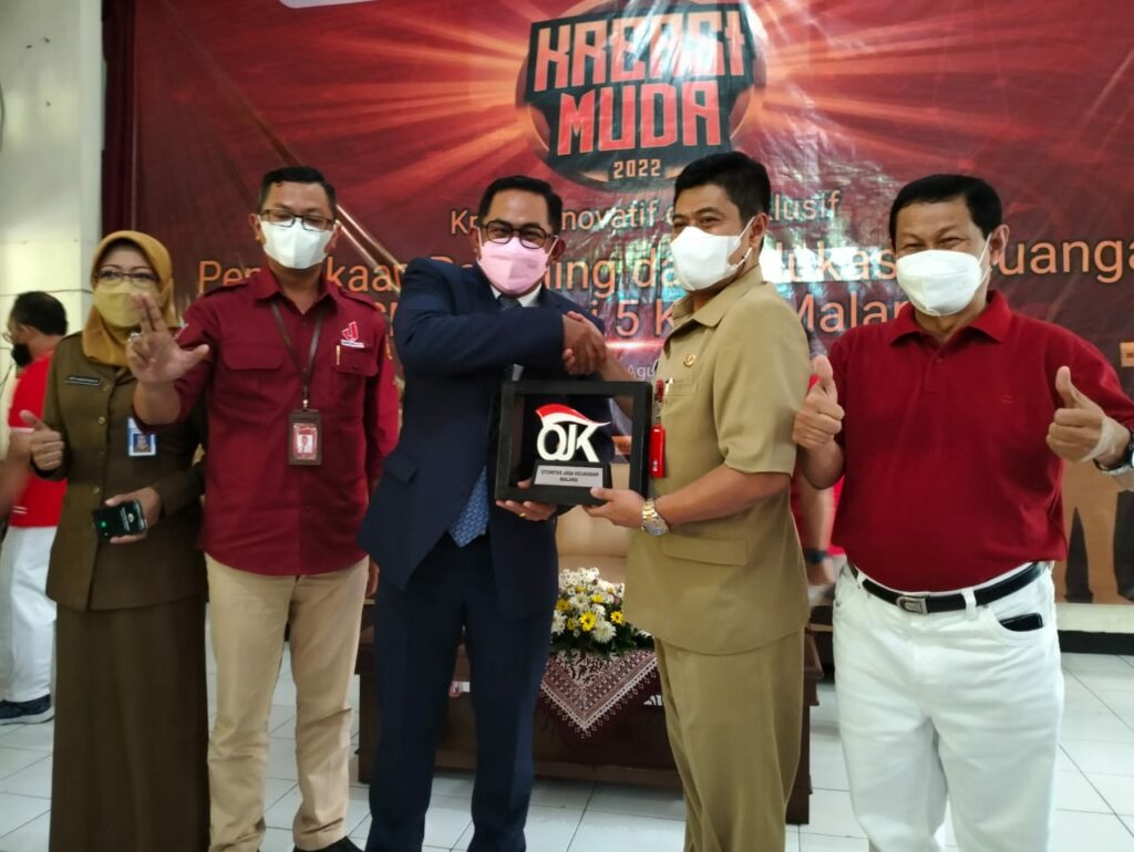 Kepala OJK Malang, Sugiarto Kasmuri memberikan cinderamata kepada Kepala Disdikbud Kota Malang, Suwarjana (ft.cholil)