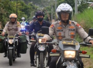 Dengan menggunakan motor trail, AKBP Oskar Syamsuddin bersama jajaran menuju lokasi penyaluran paket sembako (ist)