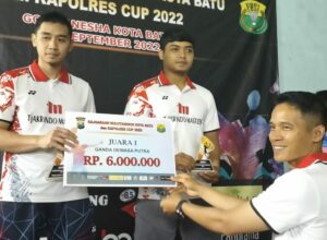Kapolres Batu, AKBP Oskar Syamsuddin, menyerahkan uang pembinaan kepada Juara 1 kategori Ganda Dewasa Putra