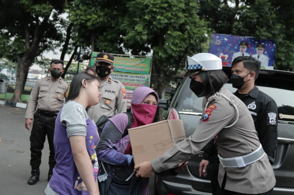 Para Polwan Polresta Malang Kota menyerahkan bantuan sembako kepada masyarakat terdampak kenaikan harga BBM