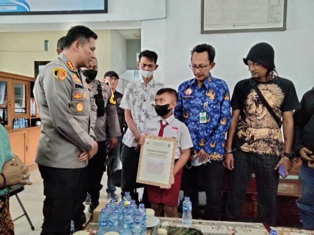 Kapolresta Malang Kota, Kombes Pol Budi Hermanto memberikan beasiswa kepada Muhammad Alfiansyah, anak dari korban insiden Kanjuruhan (ft.cholil)