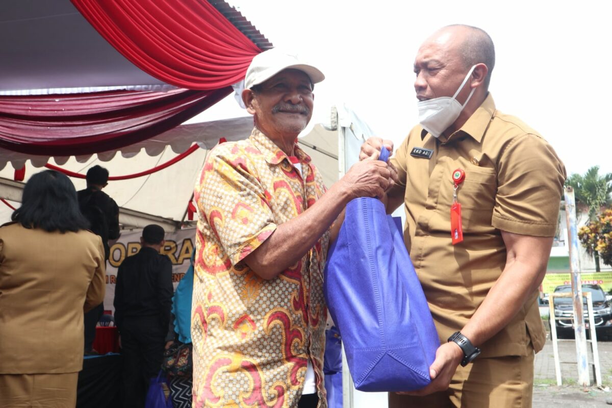 Kepala Diskopindag Kota Malang, Eko Sri Yuliadi membantu salah satu warga mengangkat barang belanjaan di gelaran Operasi Pasar (ist)