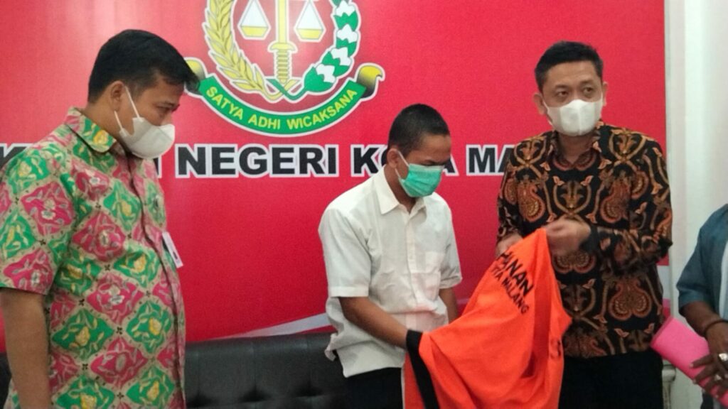 Pelepasan baju tahanan olh tersangka M Kurniawan disaksikan Kepala Kejaksaan Negeri Kota Malang, Edy Winarko serta Kasi Pidum Kusbiantoro (ft.cholil)