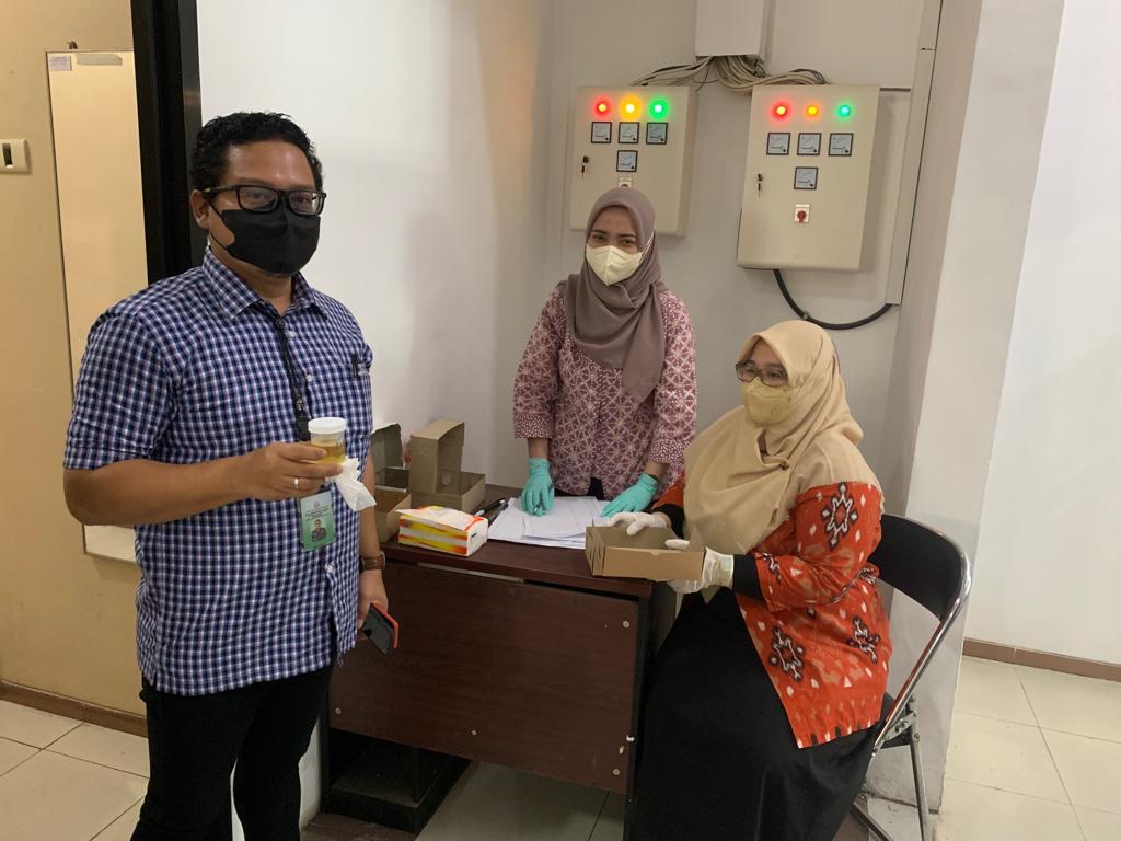 Kasi Intelijen Kejari Kota Malang, Eko Budisusanto tampak memegang botol kecil tempat urine. (istimewa)