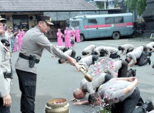 Tradisi penyiraman air bunga oleh Kapolresta Malang Kota, Kombes Pol Budi Hermanto kepada puluhan anggotanya yang naik pangkat. (istimewa)