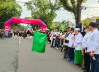 Walikota Malang, H Sutiaji (mengangkat bendera) memberangkatkan peserta gerak jalan sehat kreatif dalam peringatan Satu Abad Nahdlatul Ulama