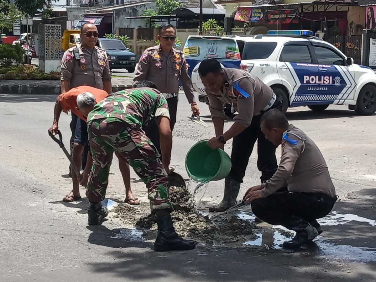 Jajaran Polresta Malang Kota bersama TNI melakukan penambalan jalan berlubang. (istimewa)