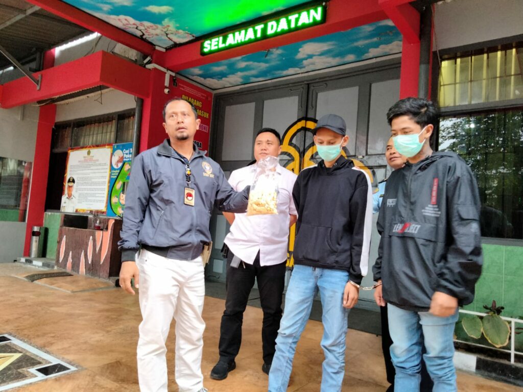 Iptu Hengky dan petugas Satresnarkoba membawa dua terduga pelaku menuju Polresta Malang Kota