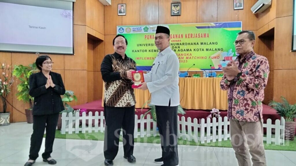 Prof Suko Wiyono memberikan cinderamata kepada Kepala Kemenag Kota Malang, KH Achmad Shampton