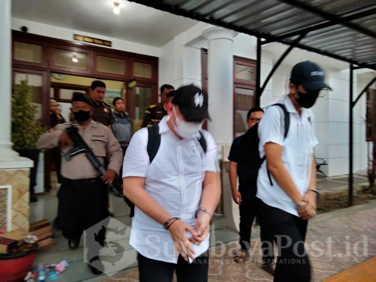 DILIMPAHKAN : Tersangka Wahyu Kenzo (baju putih kiri) dan Bayu Walker saat dibawa ke mobil tahanan usai dilimpahkan oleh Bareskrim Polri ke Kejari Kota Malang, Senin (17/07/2023) siang