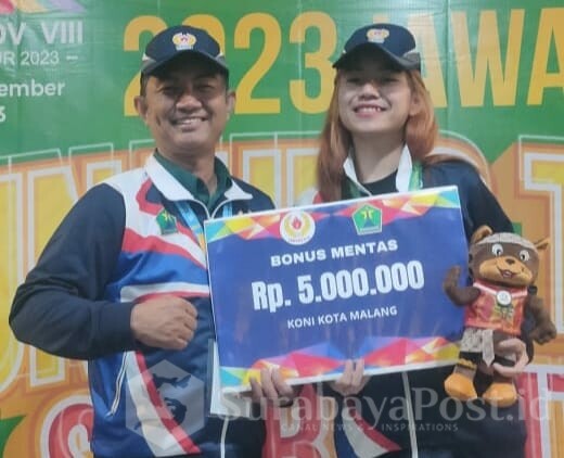 Perwakilan KONI Kota Malang, Joko Purwosusanto menyerahkan bonus kepada salah satu atlet peraih medali emas