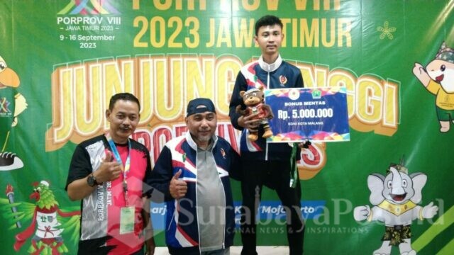 Ketua KONI Kota Malang, Djoni Sudjatmoko mengalungkan medali dan memberikan bonus kepada Supratama Aprilio, Atlet Biliar Kota Malang