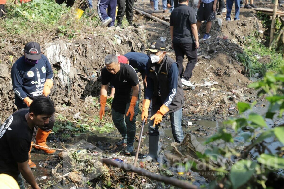Pj Wali Kota Malang, Wahyu Hidayat saat membersihkan sampah di sungai. (Dok.Prokompin Setda Kota Malang)