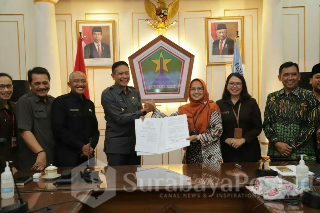 Pj Walikota Wahyu Hidayat dan Ketua KPU Kota Malang, Aminah Asminingtyas menunjukkan bukti penandatanganan. (Dok. Prokompim)
