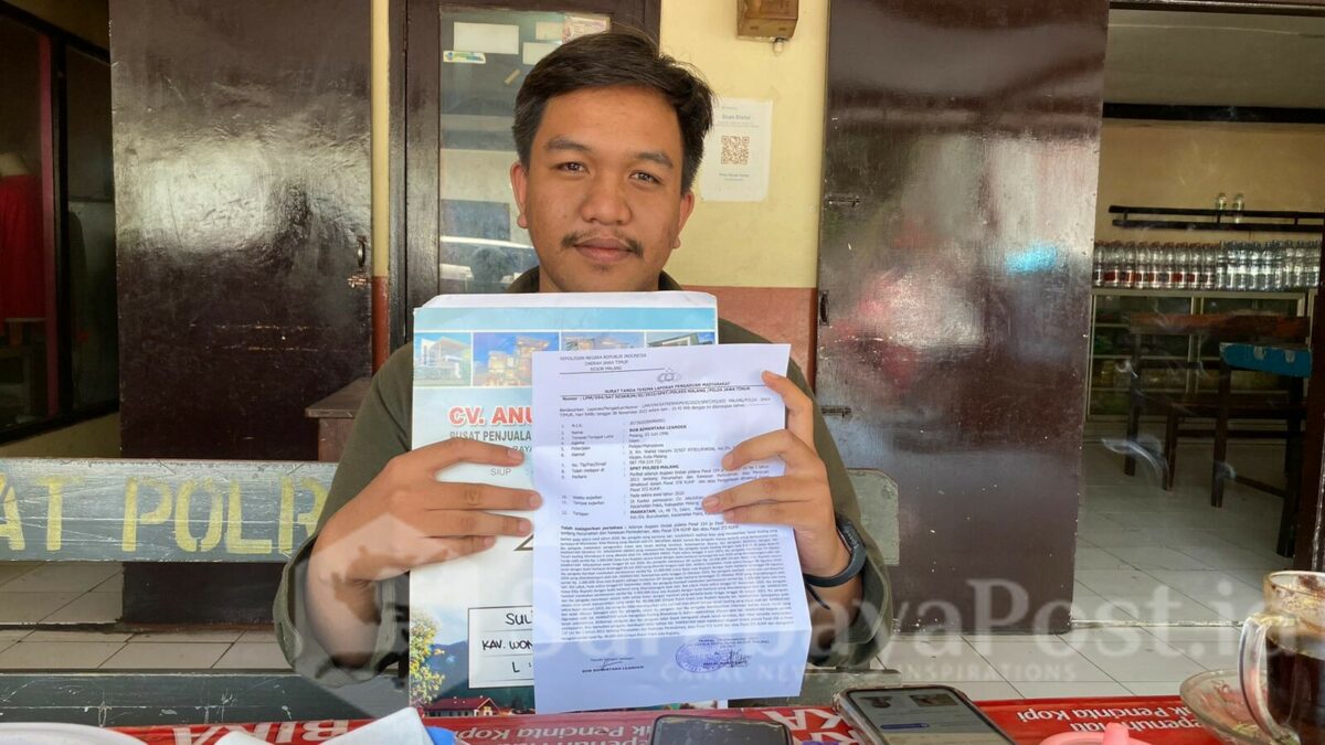 Bob (27), menunjukkan bukti laporan dugaan penipuan jual beli tanah kavling di Polres Malang. (ist)