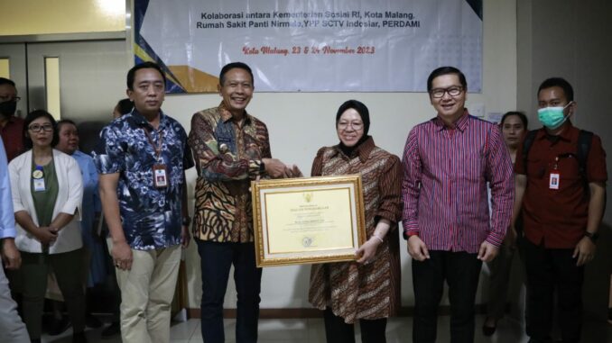 Pj. Walikota Malang, Dr. Ir. Wahyu Hidayat, M.M menerima Piagam Penghargaan dari Menteri Sosial RI, Dr. (H.C.) Ir. Hj. Tri Rismaharini, M.T. (Dok. Prokompim)