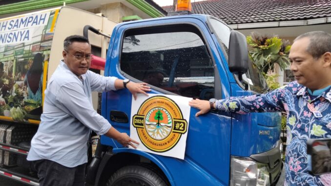 Kepala DLH Kota Malang, Noer Rahman Wijaya melakukan pemasangan stiker khusus pada kendaraan pengangkut sampah