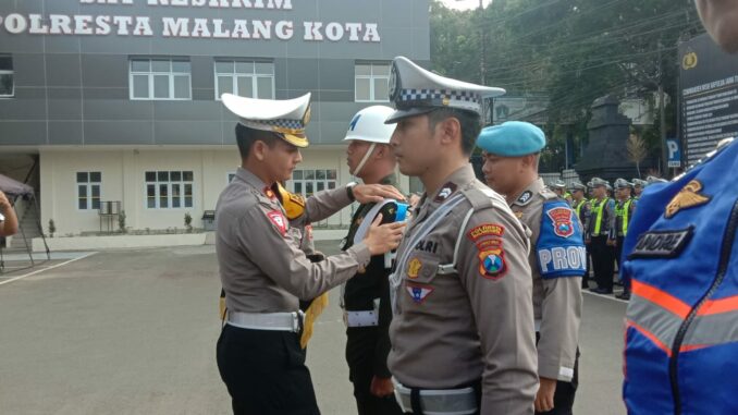 Kasat Lantas Polresta Malang Kota, Kompol Aristianto Budi Sutrisno menyematkan tanda pita kepada anggota yang terlibat dalam Operasi Keselamatan Semeru 2024, Jumat (01/03/2024).