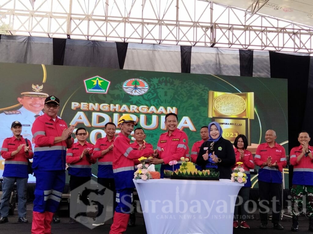 Pj. Wahyu Hidayat menyerahkan potongan nasi tumpeng kepada pegawai senior dilingkungan DLH Kota Malang