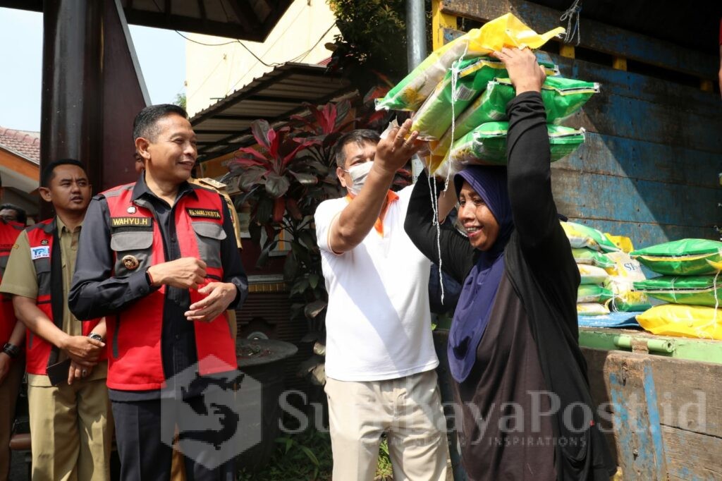 Pj Wahyu Hidayat menyaksikan salah satu warga usai membeli sembako. (Sumber Prokompim)