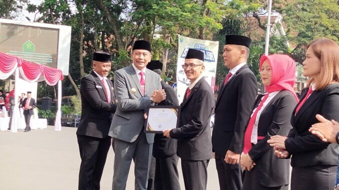 Pj. Wali Kota Malang, Wahyu Hidayat saat memberikan penghargaan peraih terbaik tekan Stunting di lingkungan Pemerintah Kota Malang, Senin (20/05/2024)