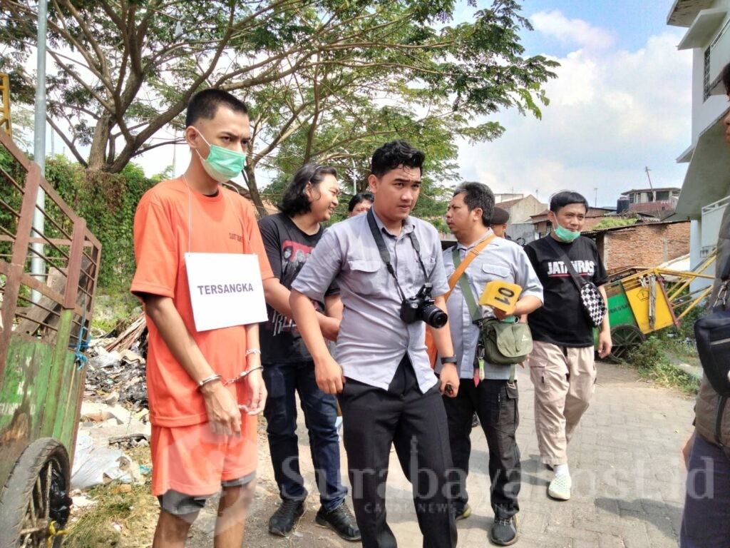 Dengan tangan diborgol, tersangka Hisyam dengan pengawalan Satreskrim unit Resmob melakukan adegan rekonstruksi