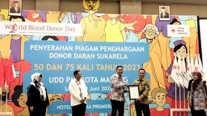 PIAGAM: Pj Wahyu Hidayat didampingi Ketua PMI Kota Malang, Imam Buchori dan Kepala UDD PMI Kota Malang, Enny Sekar Rengganingati, saat memberikan piagam penghargaan kepada ratusan pendonor darah, Sabtu (29/06/2024)