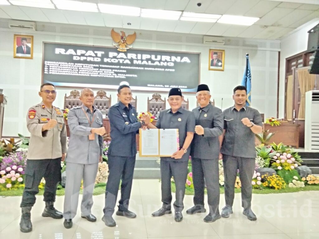 Ketua DPRD Kota Malang I Made Riandiana Kartika dan Pj Wali Kota Malang Wahyu Hidayat menunjukkan bukti pengesahan rancangan KUPA-PPAS APBD Kota Malang 2024, Kamis (25/07/2024).