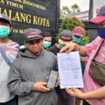 Supandi paman korban, menunjukkan bukti laporan dan foto korban yang saat ini dirawat di RSSA Malang yang diduga dianiaya majikannya, Selasa (01/10/2024) siang