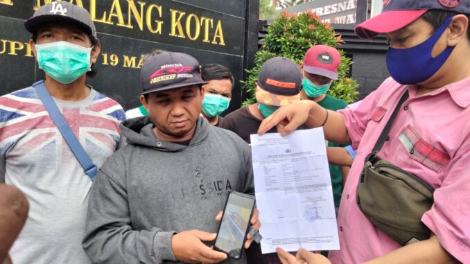 Supandi paman korban, menunjukkan bukti laporan dan foto korban yang saat ini dirawat di RSSA Malang yang diduga dianiaya majikannya, Selasa (01/10/2024) siang