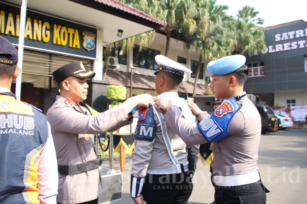 SIMBOLIS : Penyematan pita personel dalam pelaksanaan Operasi Zebra Semeru 2024 oleh Wakapolresta Malang Kota AKBP Adhitya Panji Anom usai Apel Gelar Pasukan di halaman Mapolresta Malang Kota