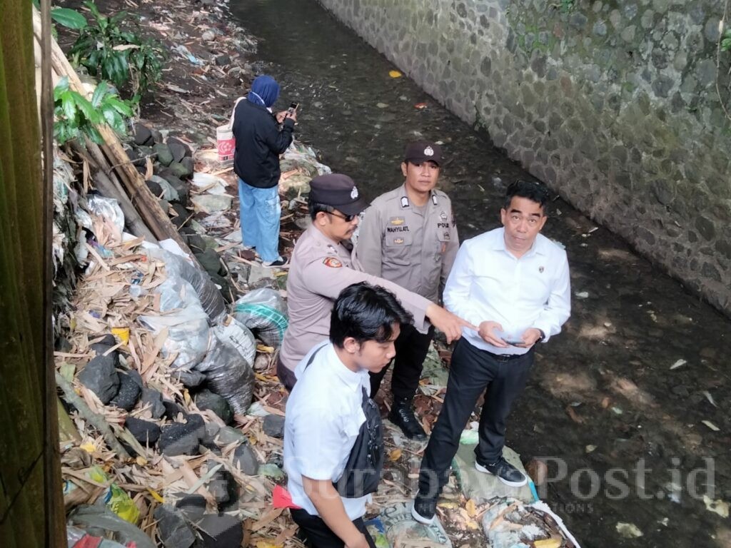 Petugas Kepolisian dari Polsek Sukun menunjukkan lokasi ditemukannya mayat pria mengapung